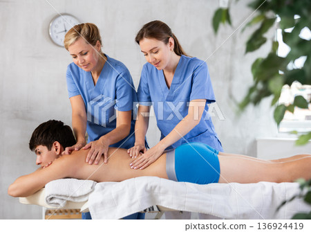 Professional masseuse teaching massage techniques to trainee Professional masseuse teaching massage techniques to trainee 136924419
