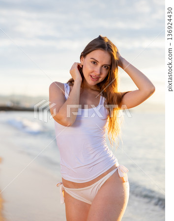 Girl with gorgeous figure on the sea during sunset. Sexy girl on wild beach Girl with gorgeous figure on the sea during sunset. Sexy girl on wild beach 136924430