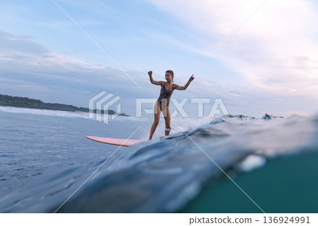Peaceful Woman Cruises Smoothly Along Shoreline On Her Longboard Peaceful Woman Cruises Smoothly Along Shoreline On Her Longboard 136924991