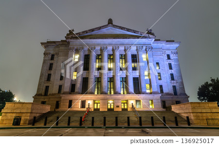 Night view of the illuminated neoclassical architecture of the Oklahoma State Capitol building with wide stairs and tall columns in Oklahoma City, Oklahoma, United States. Night view of the illuminated neoclassical architecture of the Oklahoma State Capitol building with wide stairs and tall columns in Oklahoma City, Oklahoma, United States. 136925017