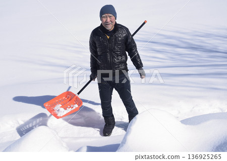 Snow removal by an elderly man living in a heavy snow area Snow removal by an elderly man living in a heavy snow area 136925265