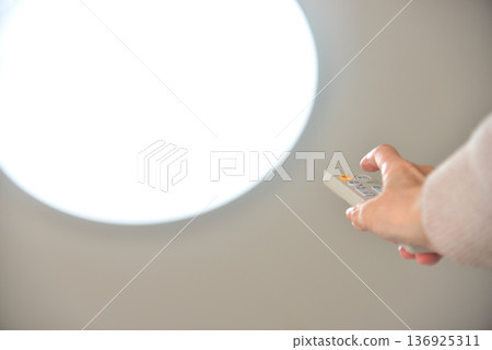 Hand operating the LED lighting remote control Hand operating the LED lighting remote control 136925311