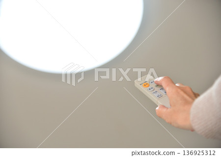 Hand operating the LED lighting remote control 136925312