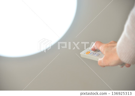 Hand operating the LED lighting remote control Hand operating the LED lighting remote control 136925313