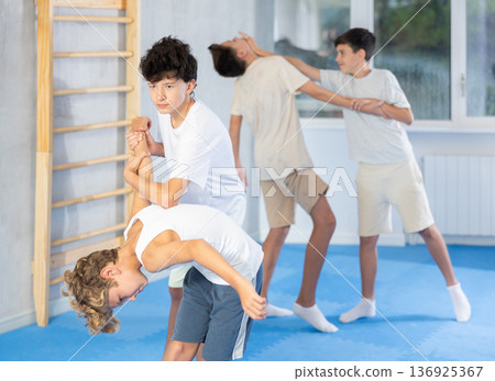 Teen boys practicing armlock in training bout during self defence course 136925367