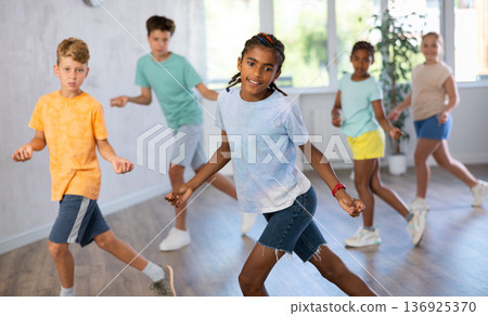 Happy african american tween boy practicing energetic dance Happy african american tween boy practicing energetic dance 136925370