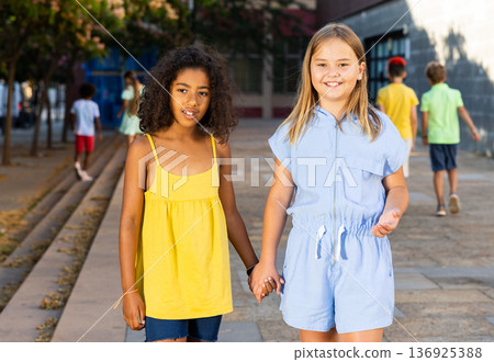 Two young girls walking through city streets together Two young girls walking through city streets together 136925388