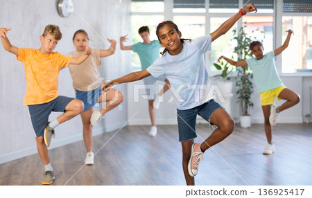 African boy perform choreographic exercises and teach energetic social dance waacking with friends African boy perform choreographic exercises and teach energetic social dance waacking with friends 136925417