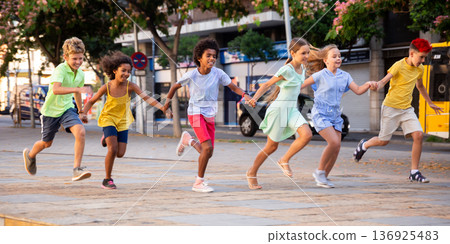 Group of happy running through city streets Group of happy running through city streets 136925483