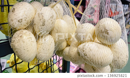 Elegant white and gold speckled Easter eggs in mesh bags, rustic holiday decorations in a store. Elegant white and gold speckled Easter eggs in mesh bags, rustic holiday decorations in a store. 136925821