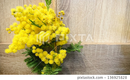 Bright yellow mimosa flowers on a wooden background, spring floral composition with copy space. Bright yellow mimosa flowers on a wooden background, spring floral composition with copy space. 136925828