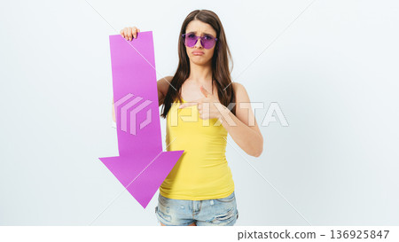 Woman is holding a purple sign that says "down" Woman is holding a purple sign that says "down" 136925847