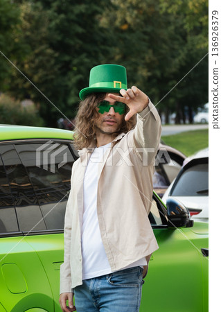 Man in green hat near car celebrating St Patrick day Man in green hat near car celebrating St Patrick day 136926379