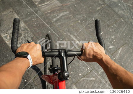 POV cyclist hands on bicycle handlebar wearing smartwatch outdoors POV cyclist hands on bicycle handlebar wearing smartwatch outdoors 136926410