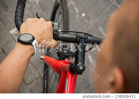 Close up of smartwatch on cyclist wrist on bicycle handlebar Close up of smartwatch on cyclist wrist on bicycle handlebar 136926411