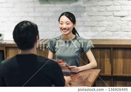 A woman receiving instructions at a gym A woman receiving instructions at a gym 136926495
