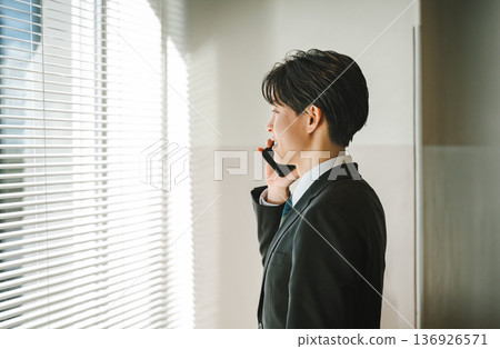 A young businessman who speaks with a smartphone A young businessman who speaks with a smartphone 136926571