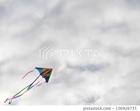 Colorful kite flying in cloudy sky Colorful kite flying in cloudy sky 136926735