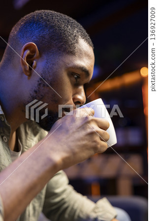 Male analyst examining monthly budget and expenses to provide strategic advice on products and services. Black young business expert analyzing revenue balance, accounting at home. Close up. Male analyst examining monthly budget and expenses to provide strategic advice on products and services. Black young business expert analyzing revenue balance, accounting at home. Close up. 136927009
