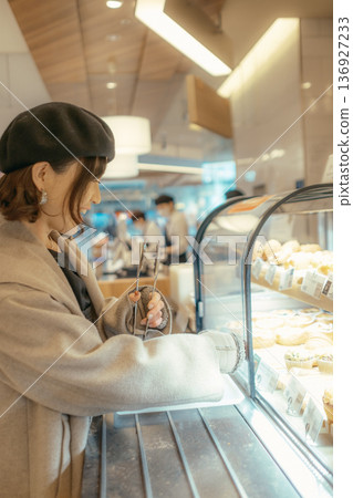 Japanese woman choosing bread at a bakery Japanese woman choosing bread at a bakery 136927233