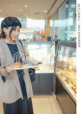 Japanese woman choosing bread at a bakery Japanese woman choosing bread at a bakery 136927240