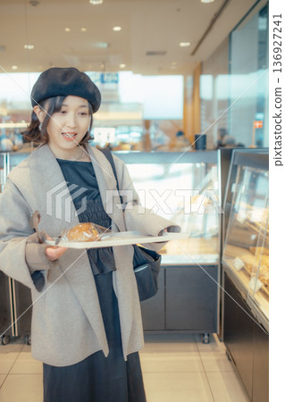 Japanese woman choosing bread at a bakery Japanese woman choosing bread at a bakery 136927241