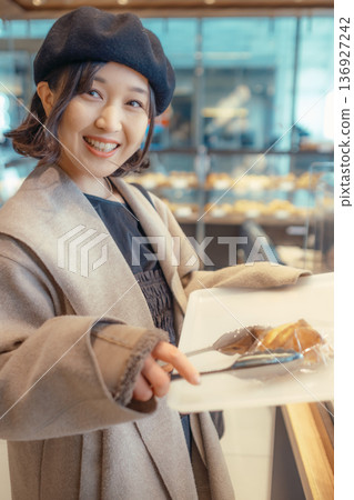 Japanese woman choosing bread at a bakery Japanese woman choosing bread at a bakery 136927242