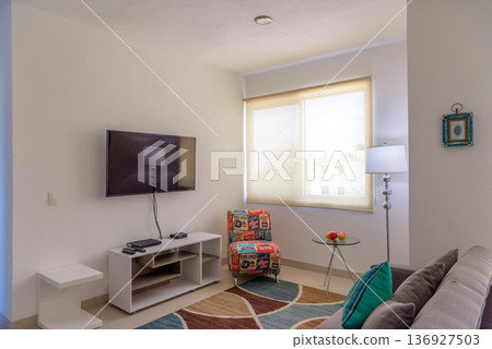Bright living room with tv and colorful retro armchair Bright living room with tv and colorful retro armchair 136927503