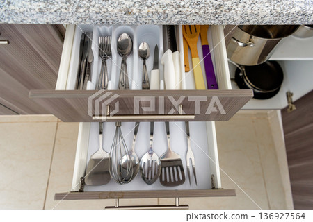 Organized cutlery drawer with silverware and cooking utensils Organized cutlery drawer with silverware and cooking utensils 136927564
