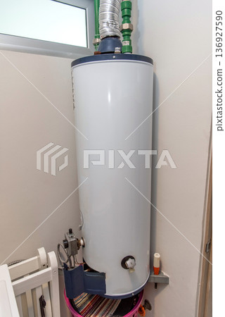 Residential gas water heater with pipe connections installed Residential gas water heater with pipe connections installed 136927590