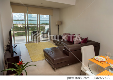 Modern living room with lagoon view and balcony access Modern living room with lagoon view and balcony access 136927629
