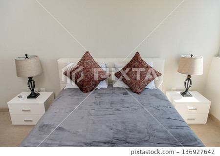 Symmetrical bedroom setup with lamps and pillows Symmetrical bedroom setup with lamps and pillows 136927642