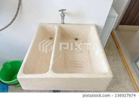Utility sink in apartment laundry area Utility sink in apartment laundry area 136927674
