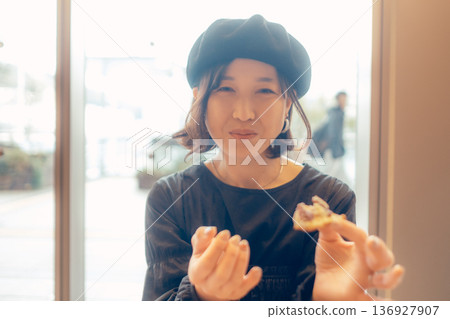 Japanese woman eating bread at a cafe Japanese woman eating bread at a cafe 136927907