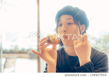 一位日本女性在咖啡館吃麵包 一位日本女性在咖啡館吃麵包 136927910