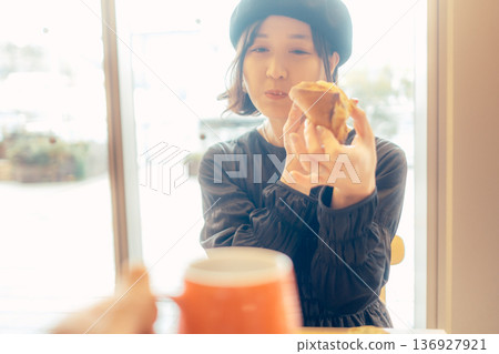 一位日本女性在咖啡館吃麵包 136927921