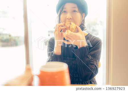 一位日本女性在咖啡館吃麵包 一位日本女性在咖啡館吃麵包 136927923