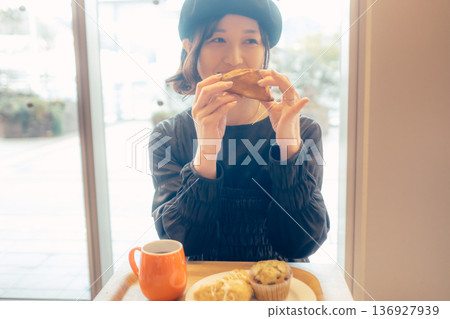 一位日本女性在咖啡館吃麵包 136927939