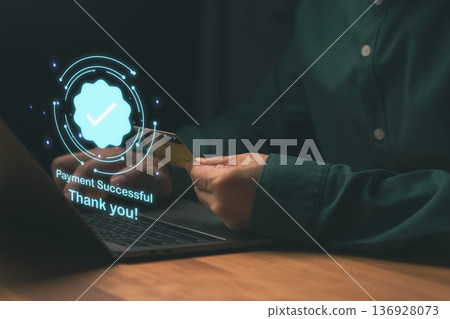Online payment success concept, man holding credit card near laptop with check mark icon and confirmation message, symbolizing secure transaction, digital banking, e-commerce, financial technology. 136928073