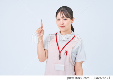 A woman in a white coat posing with her fingers raised A woman in a white coat posing with her fingers raised 136928571