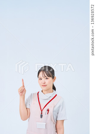 一個穿著白大褂的女人舉起手指擺姿勢 一個穿著白大褂的女人舉起手指擺姿勢 136928572