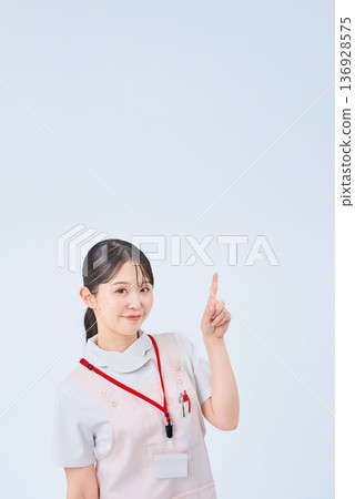 A woman in a white coat posing with her fingers raised A woman in a white coat posing with her fingers raised 136928575