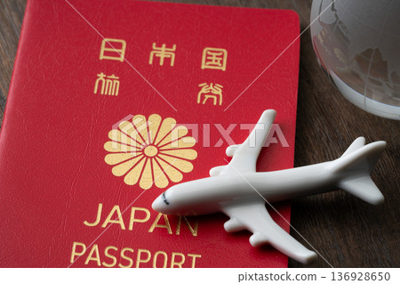 A red Japanese passport with a miniature airplane and the Earth A red Japanese passport with a miniature airplane and the Earth 136928650