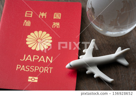 A red Japanese passport with a miniature airplane and the Earth A red Japanese passport with a miniature airplane and the Earth 136928652