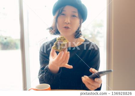 成年女性在咖啡館享用甜點 成年女性在咖啡館享用甜點 136928826