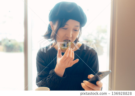 Adult woman enjoying sweets at a cafe Adult woman enjoying sweets at a cafe 136928828