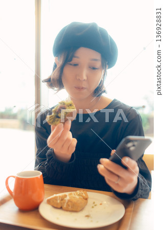 Adult woman enjoying sweets at a cafe 136928831