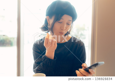 Adult woman enjoying sweets at a cafe Adult woman enjoying sweets at a cafe 136928834