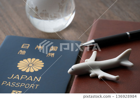 藍色日本護照和筆記本，圖案為飛機和迷你地球儀。 136928984
