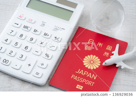 一本紅色的日本護照，一個有飛機和地球微縮模型的計算器。 136929036